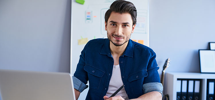 male ux designer at laptop with design pen