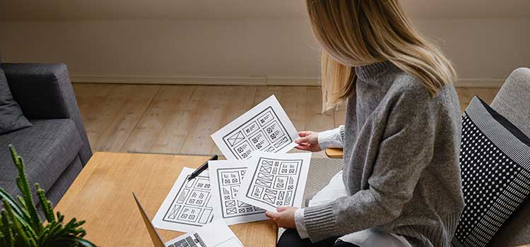 female ux designer compares user flow wireframes