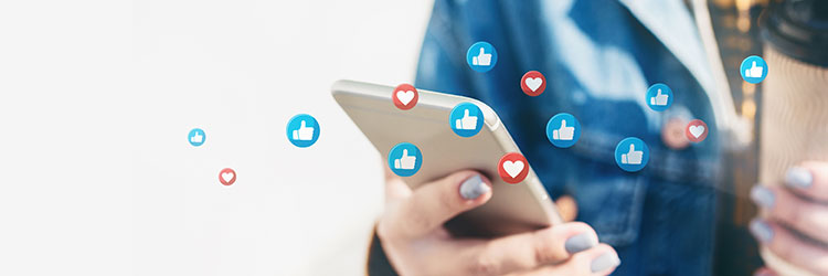hand on smartphone with lots of like and heart icons floating over